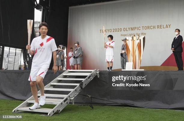 Former pro tennis player Shuzo Matsuoka is pictured during a flame-lighting ceremony in Machida, western Tokyo, on July 9 as the torch relay on...