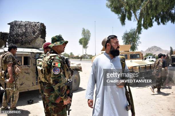Afghan security personnel stand guard along the road amid ongoing fight between Afghan security forces and Taliban fighters in Kandahar on July 9,...