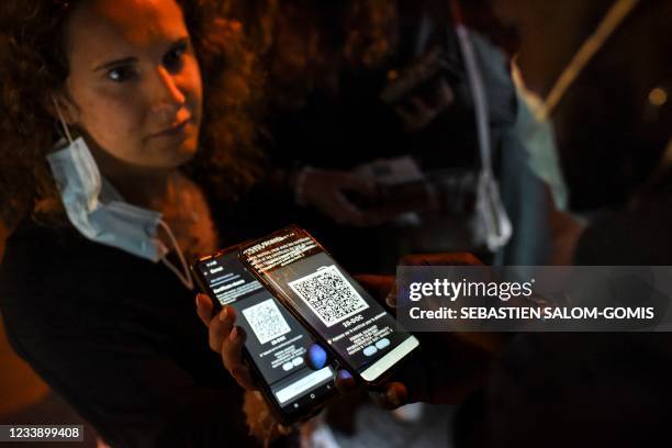 Security staff member checks the health pass of a client, at the entrance of a nightclub in Saint-Jean-de-Monts, western France, on early July 10,...