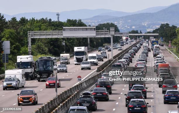 Motorists drive and queue in their vehicles on the A7 motorway between Lyon and Vienne, southeastern France, during a heavy traffic jam on the first...