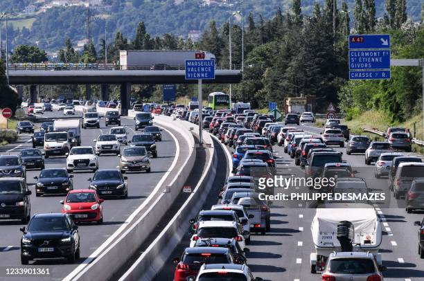 Motorists drive and queue in their vehicles on the A7 motorway between Lyon and Vienne, southeastern France, during a heavy traffic jam on the first...