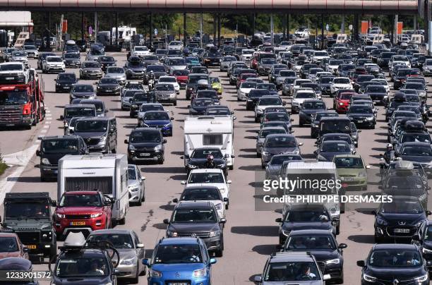 Motorists drive and queue in their vehicles at a toll station on the A7 motorway between Lyon and Vienne, southeastern France, during a heavy traffic...
