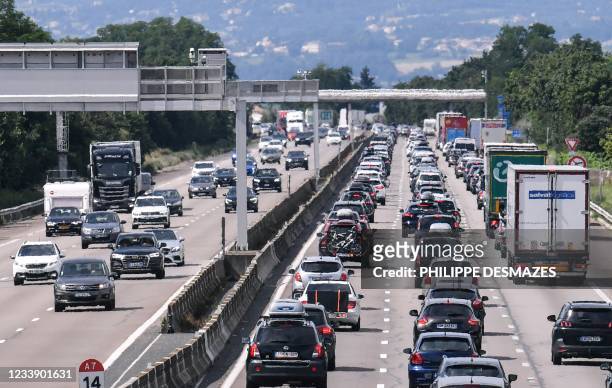 Motorists drive and queue in their vehicles on the A7 motorway between Lyon and Vienne, southeastern France, during a heavy traffic jam on the first...