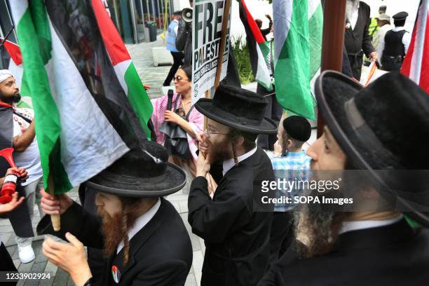 Protesters from the orthodox Jewish anti-Zionist group the Neturei Karta hold Palestinian flags and placards during a protest outside the London...