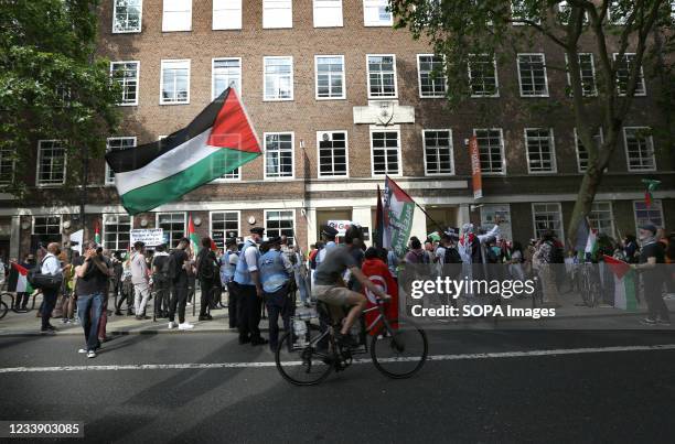 Cyclist rides past a gathering of protesters outside the University of London. Students and other protesters go on a tour of London Universities to...