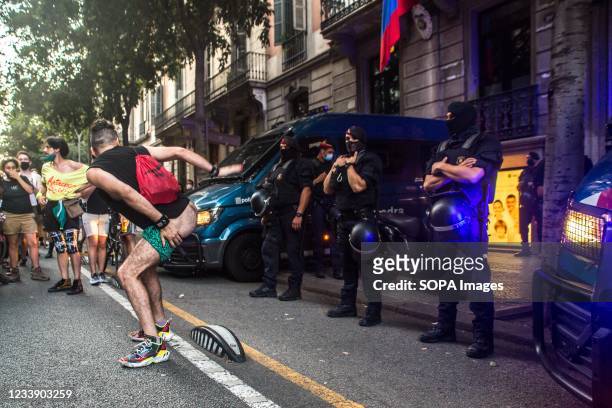 Protester shows his buttocks to police during the protest. Protesters take to the streets of Barcelona against LGTBI phobia and the death of Samuel...