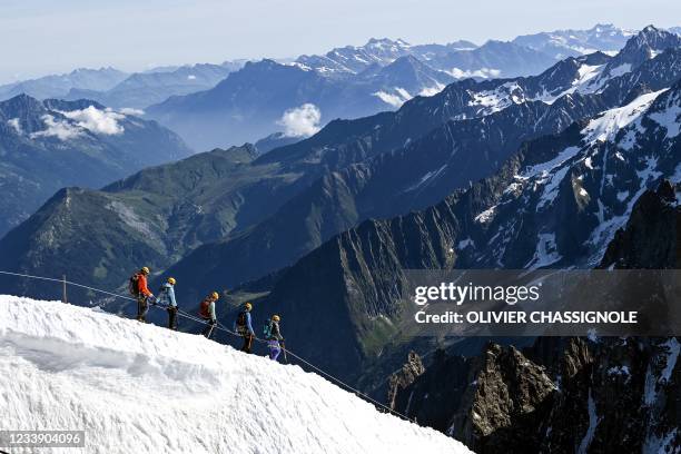 Members of the Chamonix guides company take part in a special hike, between France and Italy near the Mont Blanc mountain, on July 10 to celebrate...