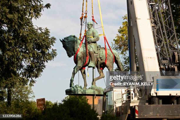 Workers remove the statue of Confederate General Robert E. Lee from a park in Charlottesville, Virginia on July 10, 2021. - The statue of Confederate...