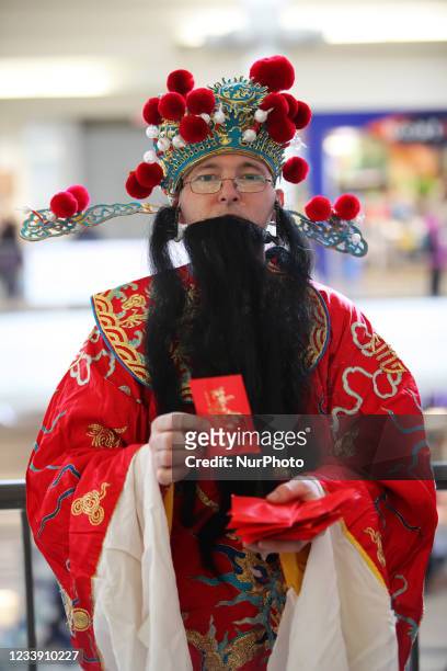 Man dressed as Cai Shen, the Chinese God of Prosperity hands out lucky red envelopes to issue in the Chinese Lunar New Year of the Tiger in Markham,...