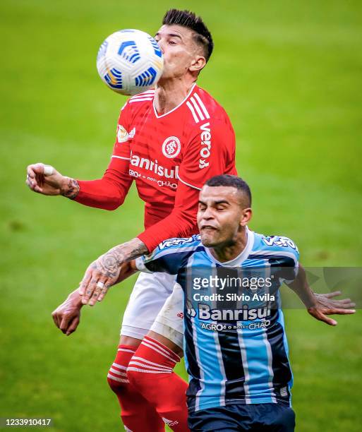 Victor Cuesta of Internacional and Alisson of Gremio fight for the ball during the match between Gremio and Internacional as part of Brasileirao...