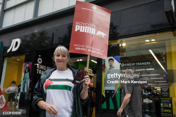 Pro-Palestinian activist canvasses support from the public outside a branch of JD Sports during a Boycott Puma day of action on 10th July 2021 in...