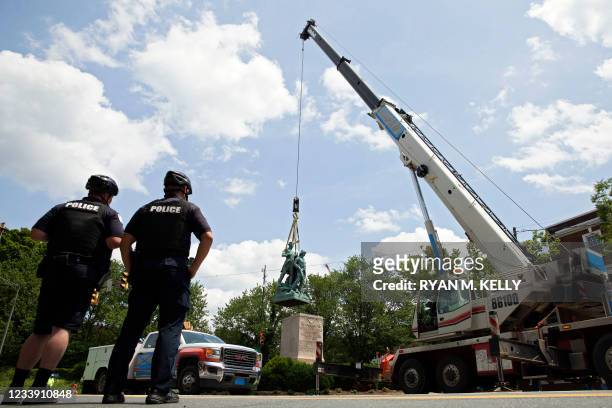 Police look on as the statue of Meriwether Lewis, William Clark and Sacagawea is removed from Charlottesville, Virginia on July 10, 2021. The...