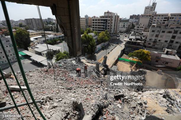 Palestinians stand on a house that was destroyed in an Israeli air strike during the fighting between Israel and Hamas in May this year, in Gaza...