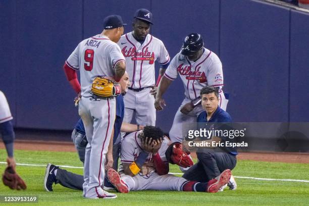 Ronald Acuna Jr. #13 of the Atlanta Braves sits with his head in this hands after an injury during the fifth inning against the Miami Marlins during...