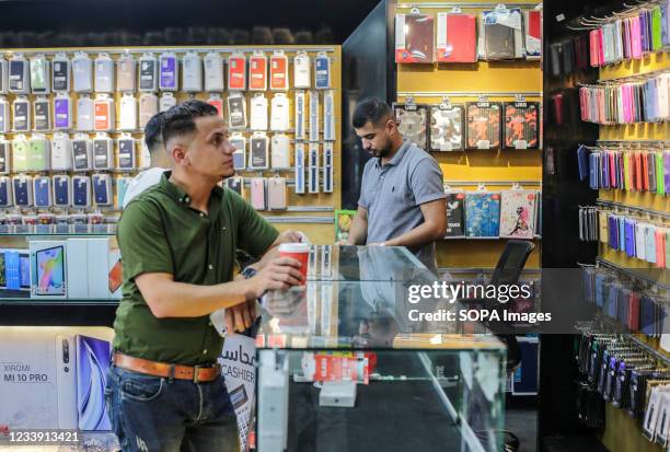 Palestinian works in a phone shop. With rising prices, unemployment rates and a lack of job opportunities in Gaza, an increasing number of families...