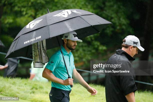 Golfer Kyle Stanley walks under an umbrella in the rain on the 6th hole during the third round of the John Deere Classic on July 10, 2021 at TPC...