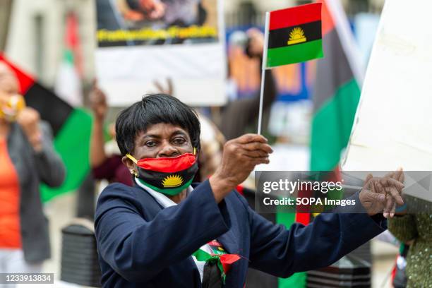 Woman dances while holding flags of Biafra during a protest in Whitehall, London. People held a protest demanding the Nigerian President Muhammadu...