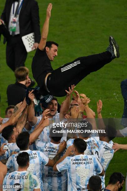 Players of Argentina celebrate by throwing Argentina's coach Lionel Scaloni into the air after winning the Conmebol 2021 Copa America football...
