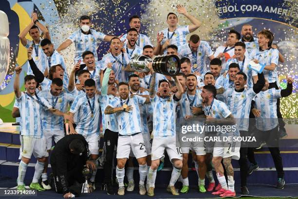 Argentina's Lionel Messi holds the trophy as he celebrates on the podium with teammates after winning the Conmebol 2021 Copa America football...