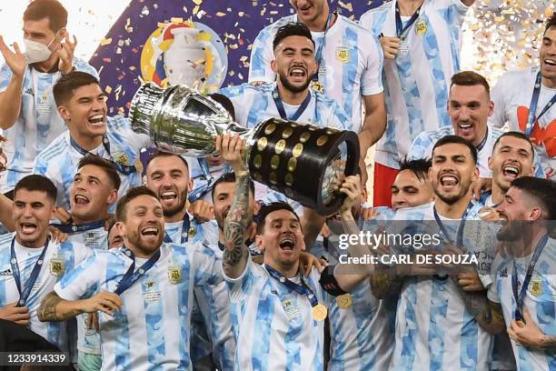 Argentina's Lionel Messi holds the trophy as he celebrates on the podium with teammates after winning the Conmebol 2021 Copa America football...