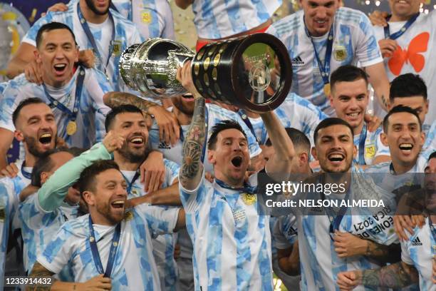 Argentina's Lionel Messi holds the trophy as he celebrates on the podium with teammates after winning the Conmebol 2021 Copa America football...