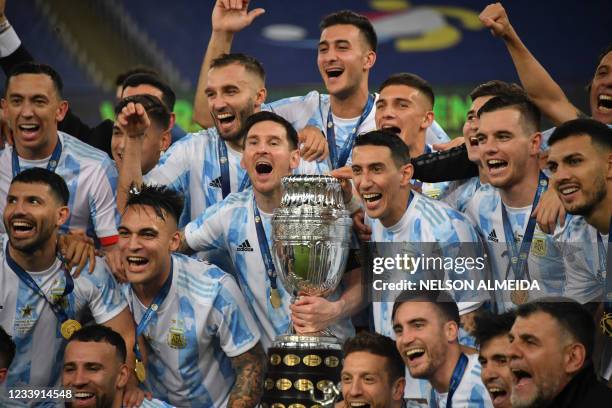 Argentina's Lionel Messi holds the trophy as he celebrates on the podium with teammates after winning the Conmebol 2021 Copa America football...