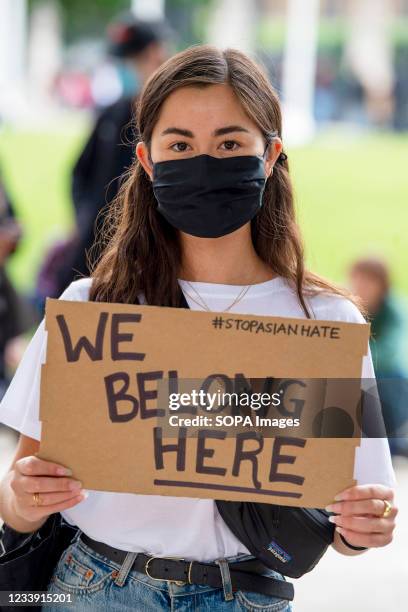 Protester holds a placard that says 'We belong here' during a Stop Asian Hate protest at Parliament Square in London. Anti-Asian violence and abuse...