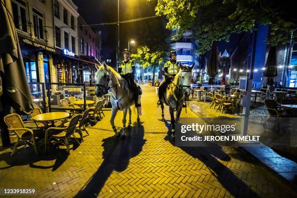 Dutch police patrole in the streets on July 10, 2021 in Utrecht, at the start of the newly implemented curfew in the country in order to fight...
