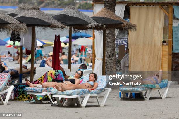 Three women sunbathe in hammocks at the beach on July 11, 2021 in Almunecar