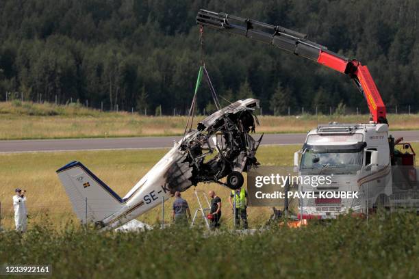 Photo taken on July 11, 2021 shows a crane lifting and moving a plane wreck from the crash site, a few days after the small aircraft crashed near...