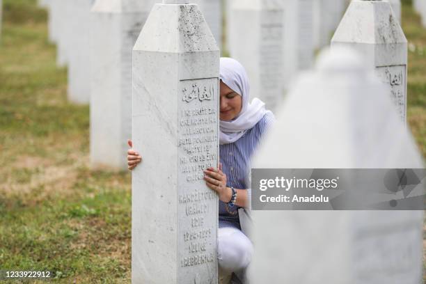 Woman mourns near a gravestone as funeral ceremony for 19 victims of the Srebrenica Genocide, whose identities have been detected, held at Potocari...
