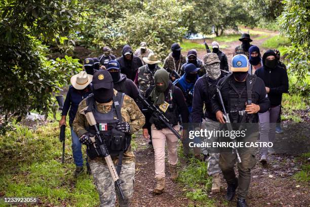 Members of the self-defense group Pueblos Unidos carry out guard duties in protection of avocado plantations, whipped by drug cartels that dominate...