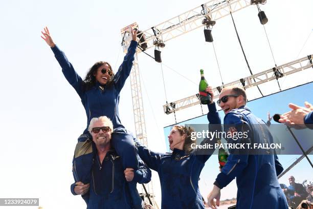 Virgin Galactic founder Sir Richard Branson, with Sirisha Bandla on his shoulders, cheers with crew members after flying into space aboard a Virgin...