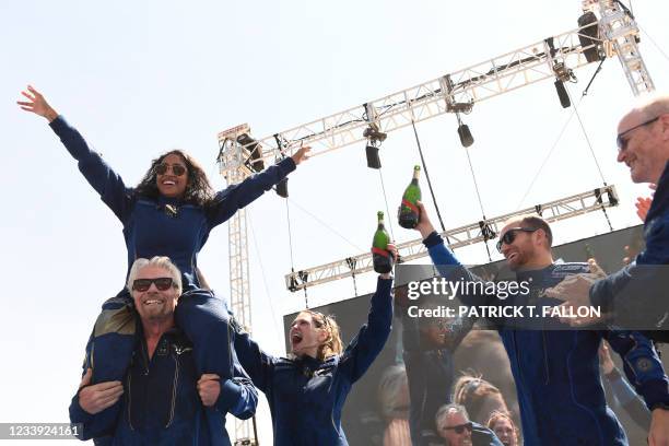 Virgin Galactic founder Sir Richard Branson, with Sirisha Bandla on his shoulders, cheers with crew members after flying into space aboard a Virgin...