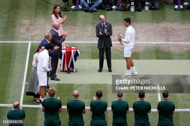 Britain's Catherine, Duchess of Cambridge, watches as Britain's Prince Edward, Duke of Kent presents Serbia's Novak Djokovic withthe winner's trophy...