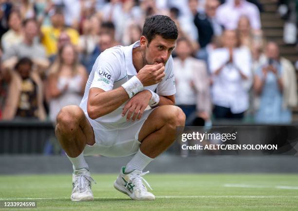 Serbia's Novak Djokovic eats some grass after his victory against Italy's Matteo Berrettini during their men's singles final match on the thirteenth...