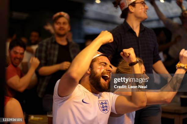 Football fans celebrate while watching the live broadcast of the final of the 2020 UEFA European Championships between England and Italy in the...