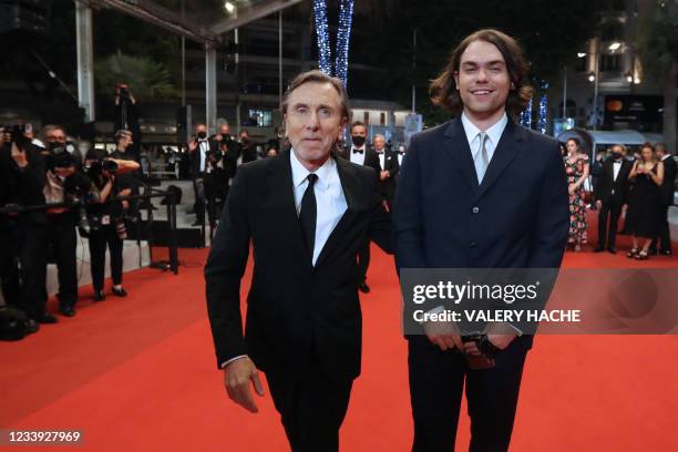 British actor Tim Roth walks by his son Michael Cormac Roth as they arrive for the screening of the film "Bergman Island" at the 74th edition of the...