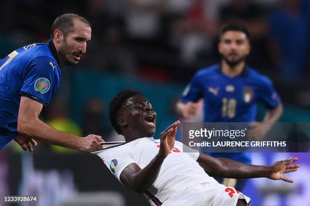 Italy's defender Giorgio Chiellini fouls England's midfielder Bukayo Saka during the UEFA EURO 2020 final football match between Italy and England at...