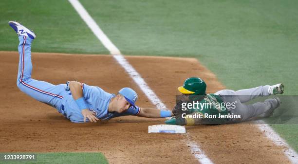 Ramon Laureano of the Oakland Athletics is caught stealing and is tagged out at first base by Nate Lowe of the Texas Rangers during the eighth inning...