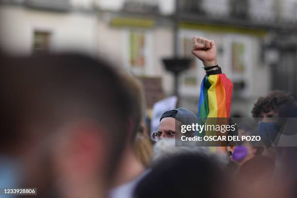 Protester dressed in the rainbow colours raises his fist as take part in a demonstration to protest against LGBTQ-phobia at the Puerta del Sol square...