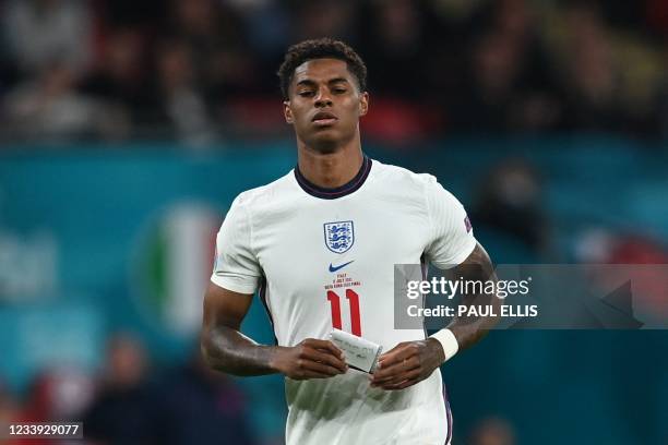 England's forward Marcus Rashford carries a note during the UEFA EURO 2020 final football match between Italy and England at the Wembley Stadium in...