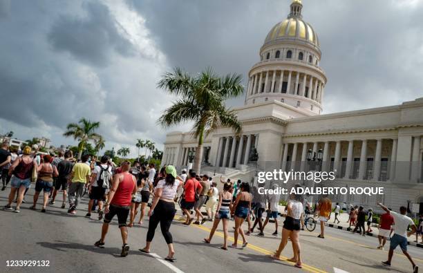 Cubans march in front of Havana's Capitol during a demonstration against the government of Cuban President Miguel Diaz-Canel in Havana, on July 11,...