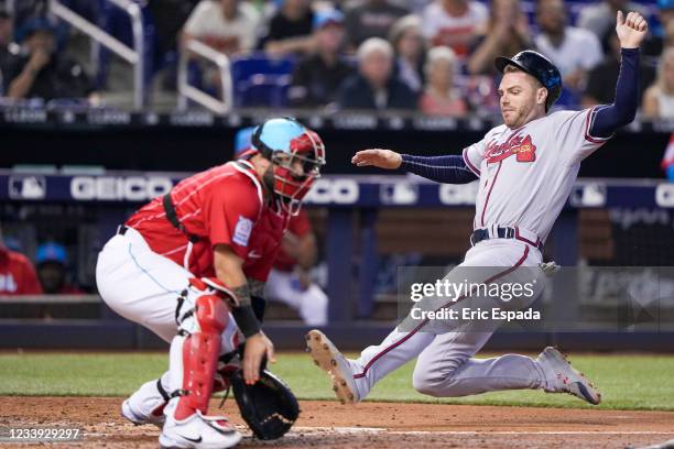 Freddie Freeman of the Atlanta Braves slides into home plate during the fourth inning against the Miami Marlins at loanDepot park on July 11, 2021 in...