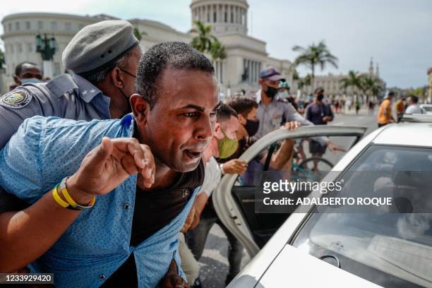 Man is arrested during a demonstration against the government of Cuban President Miguel Diaz-Canel in Havana, on July 11, 2021. - Thousands of Cubans...