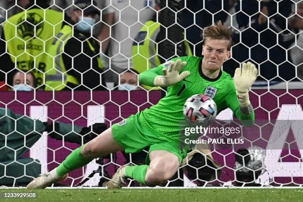 England's goalkeeper Jordan Pickford saves a shot by Italy's forward Andrea Belotti in the penalty shootout during the UEFA EURO 2020 final football...