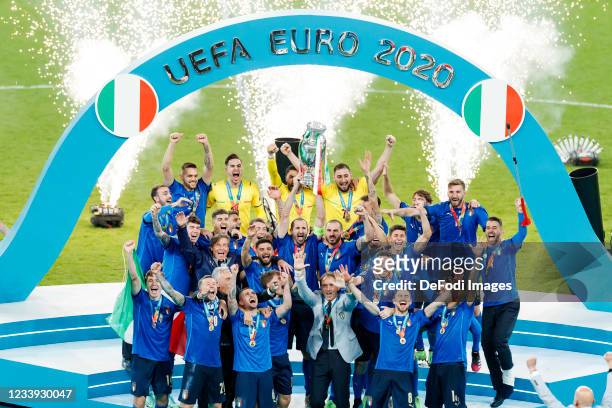 Giorgio Chiellini of Italy lifts the trophy while his team-mates celebrate after winning the UEFA Euro 2020 Championship Final between Italy and...