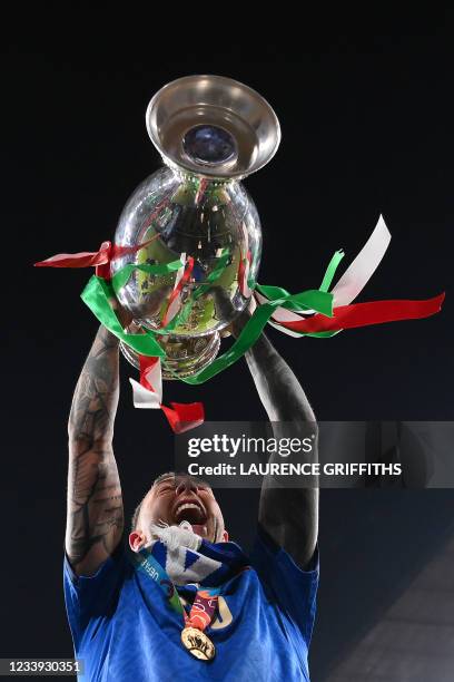 Italy's midfielder Federico Bernardeschi poses with the European Championship trophy after Italy won the UEFA EURO 2020 final football match between...