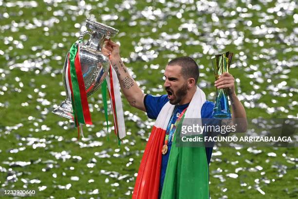 Italy's defender Leonardo Bonucci poses with the European Championship trophy, and the player of the match award, after Italy won the UEFA EURO 2020...