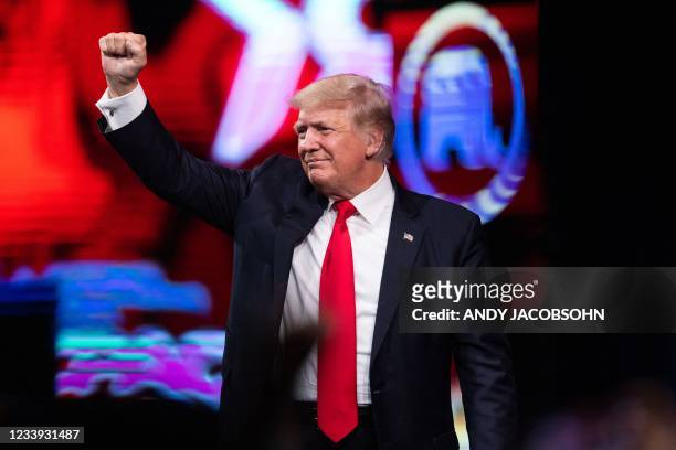 Former US President Donald Trump pumps his fist as he walks off after speaking at the Conservative Political Action Conference in Dallas, Texas on...